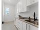 Bright laundry room features white cabinets, a sink, and stainless steel accents at 500 E Davis Blvd, Tampa, FL 33606