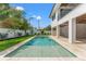Backyard swimming pool with tiled surround, shallow tanning ledge, manicured lawn, and views of the home's rear facade at 500 E Davis Blvd, Tampa, FL 33606