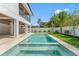Backyard swimming pool with tiled surround, shallow tanning ledge, manicured lawn, and views of the home's rear facade at 500 E Davis Blvd, Tampa, FL 33606