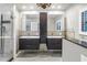 This bathroom features dual sinks, dark wood cabinets, modern fixtures, and a large mirror at 5051 5Th S Ave, St Petersburg, FL 33707