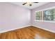 Bright bedroom featuring hardwood floors, a ceiling fan, and natural light from the window at 5051 5Th S Ave, St Petersburg, FL 33707
