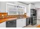 Kitchen featuring white cabinets, colorful backsplash, stainless steel sink and black appliances at 5051 5Th S Ave, St Petersburg, FL 33707