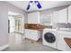 Laundry room featuring tile flooring, white cabinets, and modern washer/dryer at 5051 5Th S Ave, St Petersburg, FL 33707