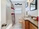 Bathroom featuring a shower-tub combo, granite vanity, and neutral tiling at 5100 Aragon S Way, St Petersburg, FL 33705