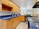 An open kitchen with wood cabinets, blue countertops, and a breakfast bar at 5100 Aragon S Way, St Petersburg, FL 33705