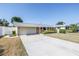 A single-story home features a long driveway leading to the garage and has neatly trimmed landscaping at 5877 33Rd N Ave, St Petersburg, FL 33710