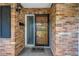 Close-up view of the front door featuring a brick surround, security door, and tiled entryway at 5877 33Rd N Ave, St Petersburg, FL 33710