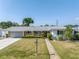 Charming single-story home featuring a well-manicured lawn, a brick accent, and a cozy front porch at 5877 33Rd N Ave, St Petersburg, FL 33710