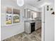 Kitchen featuring tile flooring, black dishwasher, sink, and white refrigerator at 5877 33Rd N Ave, St Petersburg, FL 33710