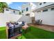Inviting backyard featuring artificial grass, wood deck, patio furniture and a white privacy wall at 723 S Brevard Ave, Tampa, FL 33606