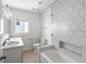 Bright bathroom with white hexagon tiles and bathtub with glass shower door at 723 S Brevard Ave, Tampa, FL 33606