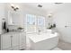 Bright bathroom featuring a modern soaking tub, single vanity, and ample natural light at 723 S Brevard Ave, Tampa, FL 33606