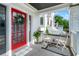 Charming front porch with a red door, stylish decor and seating for relaxing at 723 S Brevard Ave, Tampa, FL 33606
