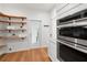 Walk-in pantry with wooden shelving, stainless steel oven, and hardwood floors at 723 S Brevard Ave, Tampa, FL 33606