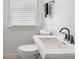 Clean powder room with modern pedestal sink, toilet, and window at 723 S Brevard Ave, Tampa, FL 33606