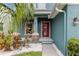 Inviting home entrance with a red door, stone accents, and lush landscaping with decorative white rock at 7513 S Sparkman St, Tampa, FL 33616