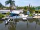 Aerial view of waterfront property with boat lift, dock, and lush landscaping at 832 Seabreeze Dr, Ruskin, FL 33570