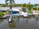 Aerial view of canal-front home with boat lift, dock, screened in patio, and fenced in yard at 832 Seabreeze Dr, Ruskin, FL 33570