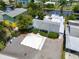 Aerial view of a quaint blue home with water access and mature tropical landscaping at 832 Seabreeze Dr, Ruskin, FL 33570