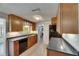 Traditional kitchen with wood cabinets, black appliances, and a view into the laundry area at 832 Seabreeze Dr, Ruskin, FL 33570