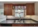 Bright kitchen with stainless steel sink, wood cabinetry, and black countertops at 832 Seabreeze Dr, Ruskin, FL 33570