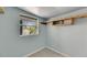 Room with light blue walls featuring a window overlooking the outside and custom shelving at 832 Seabreeze Dr, Ruskin, FL 33570