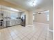 Bright kitchen featuring modern appliances, mosaic backsplash, tile floors, and easy access to other rooms at 8345 81St Ct, Seminole, FL 33777