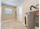 Utility room featuring tile flooring, neutral paint, a small window and updated water heater at 8345 81St Ct, Seminole, FL 33777