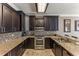 Modern kitchen featuring granite countertops, dark wood cabinets, stainless steel appliances, and tile backsplash at 8518 Broken Willow Ct, Tampa, FL 33647