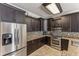 Bright kitchen featuring stainless steel refrigerator, dark wood cabinets and granite countertops at 8518 Broken Willow Ct, Tampa, FL 33647