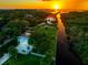 Stunning aerial perspective of the waterfront property with lush surroundings, private boat access, and mesmerizing sunset views at 8717 Betty St, Port Richey, FL 34668
