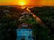Panoramic aerial view of a waterfront property featuring lush surroundings, private boat access, and captivating sunset scenery at 8717 Betty St, Port Richey, FL 34668