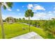 Lush backyard with tropical landscaping, a canal view, and a glimpse of nearby condos at 8717 Betty St, Port Richey, FL 34668