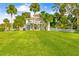 Expansive backyard with lush green lawn, white picket fence, and mature palm trees at 8717 Betty St, Port Richey, FL 34668