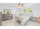 Bright bedroom featuring a large window, closet, and sleek light colored wood floors at 8717 Betty St, Port Richey, FL 34668