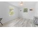 Inviting bedroom with wood-look floors, white walls, and bright windows at 8717 Betty St, Port Richey, FL 34668