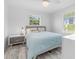 Sunlit bedroom with comfortable bed, wood-look floors, and scenic views at 8717 Betty St, Port Richey, FL 34668