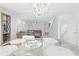 Dining area with modern chandelier, glass table, and access to the living room and staircase at 8717 Betty St, Port Richey, FL 34668