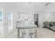 Dining area featuring a modern light fixture, glass table, and open access to the living room at 8717 Betty St, Port Richey, FL 34668