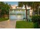 Two-story home featuring a driveway, stairs, and tropical plants at 8717 Betty St, Port Richey, FL 34668