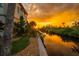 Stunning waterfront property with lush landscaping, private dock, and a serene canal view during a vibrant sunset at 8717 Betty St, Port Richey, FL 34668