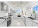 Modern kitchen featuring white cabinets, stainless steel appliances, and tile backsplash at 8717 Betty St, Port Richey, FL 34668