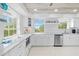 Bright, updated kitchen with white cabinetry, granite countertops, and stainless steel appliances at 8717 Betty St, Port Richey, FL 34668
