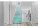 Bright stairway with colorful blue painted steps in a modern style home at 8717 Betty St, Port Richey, FL 34668