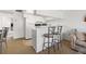 Kitchen view featuring white cabinets, bar stools, and access to the living room area at 9755 Harrell Ave # 101, Treasure Island, FL 33706