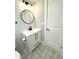 Modern bathroom with white vanity, round mirror and subway tile backsplash at 9830 Sheryl Dr, New Port Richey, FL 34654