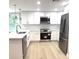 Modern kitchen featuring stainless steel appliances, white cabinetry, and marble countertops at 9830 Sheryl Dr, New Port Richey, FL 34654