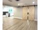 Open-concept living area with barn doors leading into another room, and light wood floors at 9830 Sheryl Dr, New Port Richey, FL 34654