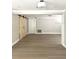 Open living room with barn doors, light wood floors, and neutral paint at 9830 Sheryl Dr, New Port Richey, FL 34654