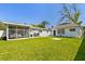 Spacious backyard with lush green lawn, screened-in patio, and a grill at 6914 N Ola Ave, Tampa, FL 33604